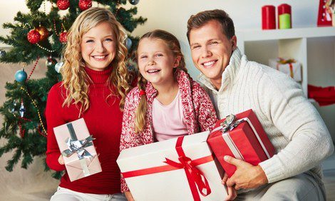 Familia posando con sus regalos de Navidad