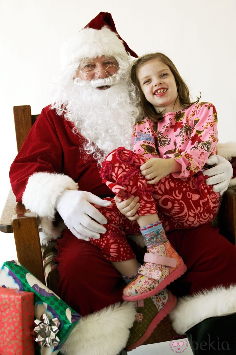 Papá Noel con una niña pidiéndole regalos de navidad